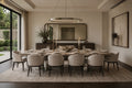 A staged dining room interior featuring a long rectangular dining table set with white tableware, surrounded by eight upholstered dining chairs in a neutral beige and gray color palette. The room is styled with a large oval ring pendant light, a long mirror, a sideboard, and a large abstract painting on the wall.